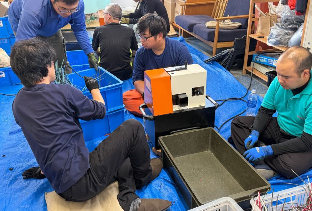 ACC松江の作業室で、スタッフと一緒に廃電線の分別作業に取り組む利用者の方々